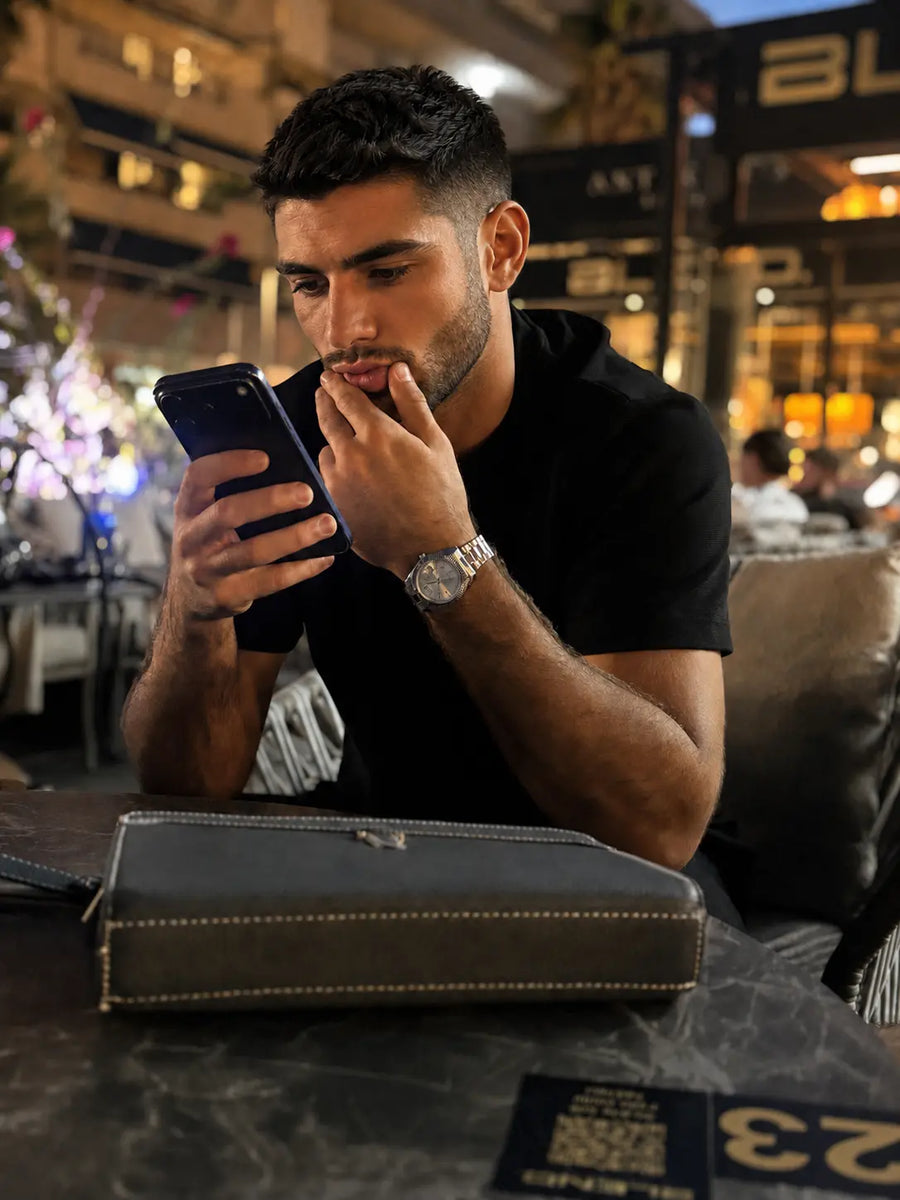 MQ watch worn at a restaurant table